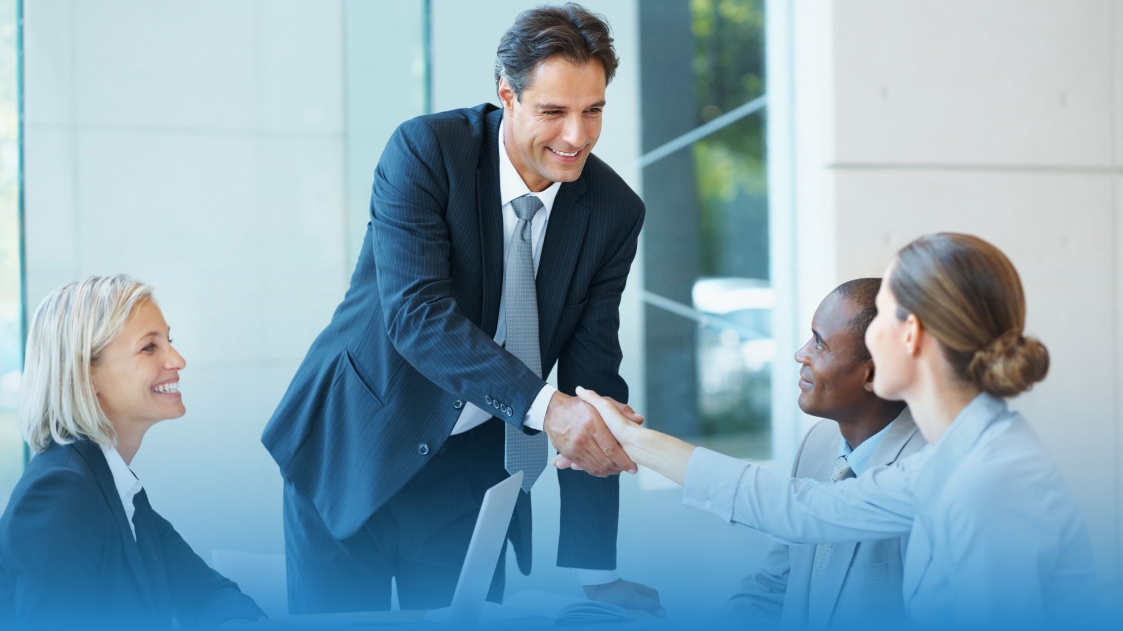 Team meeting with professionals shaking hands, representing buyer confidence built through independent DPA certification.