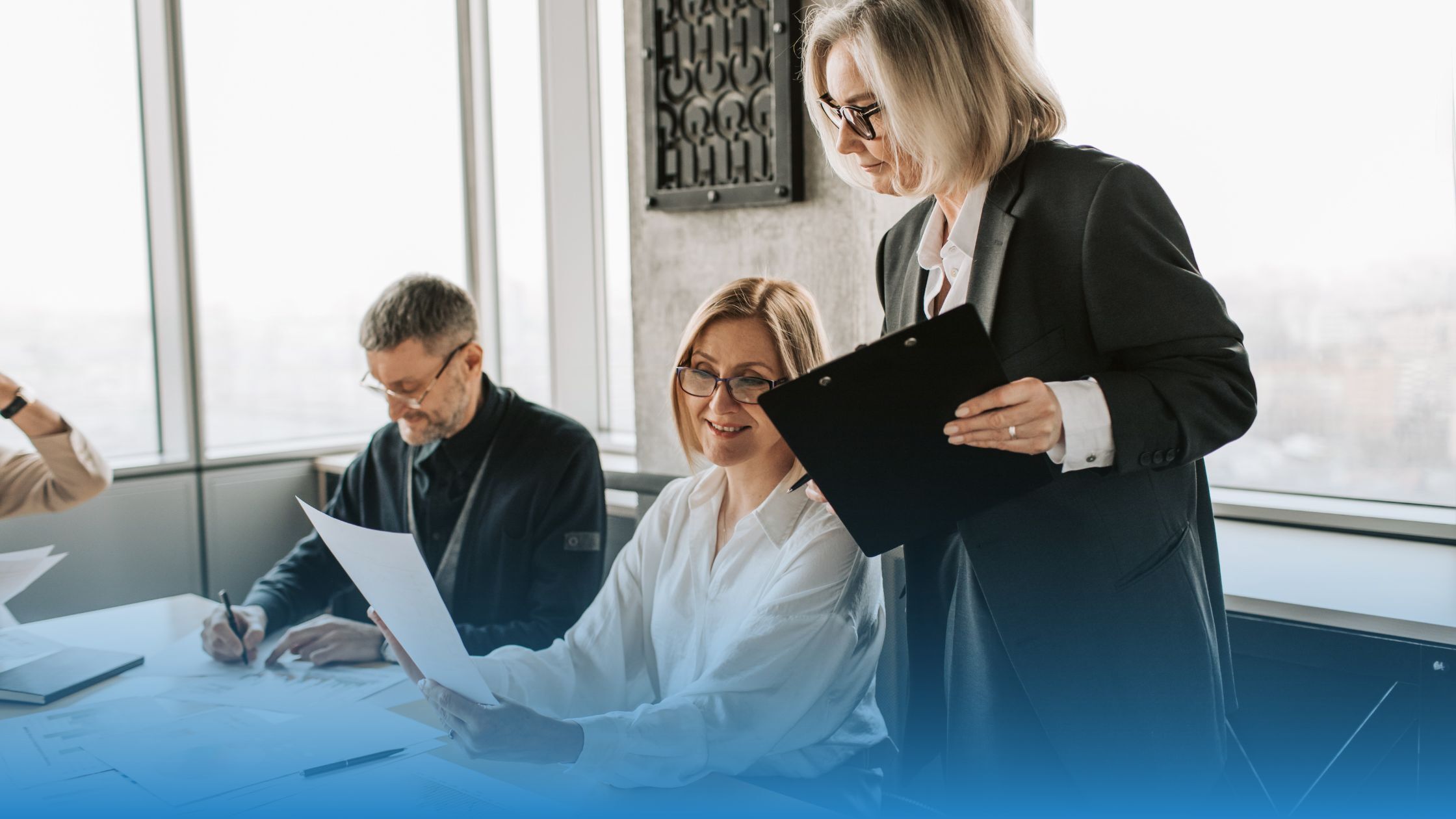 Business team reviewing documents during a year-end meeting focused on improving contract clarity.