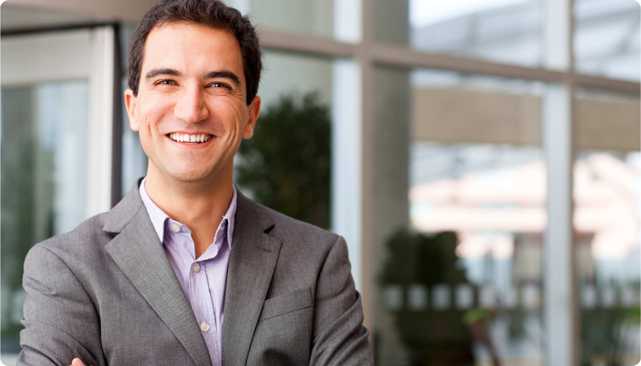 Smiling professional in a suit, representing confidence and trust in certified contract processes.