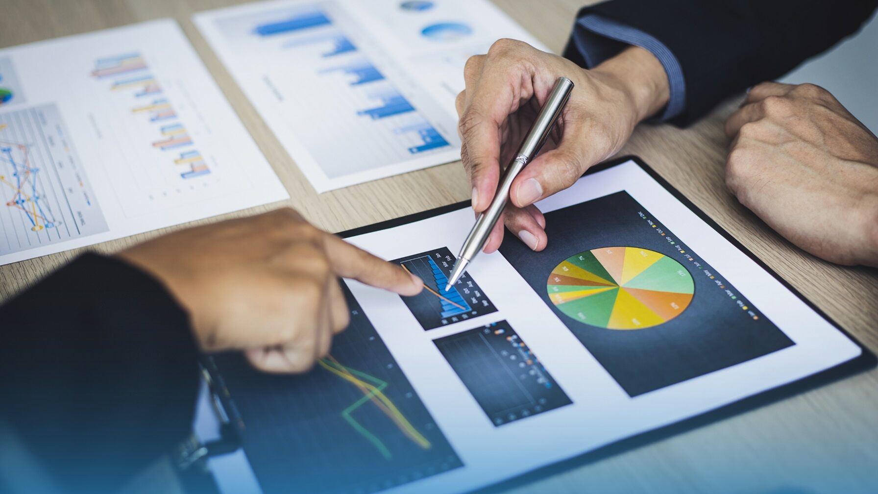 Close-up of professionals analyzing charts and graphs, highlighting data-driven insights in revenue operations and contract performance.